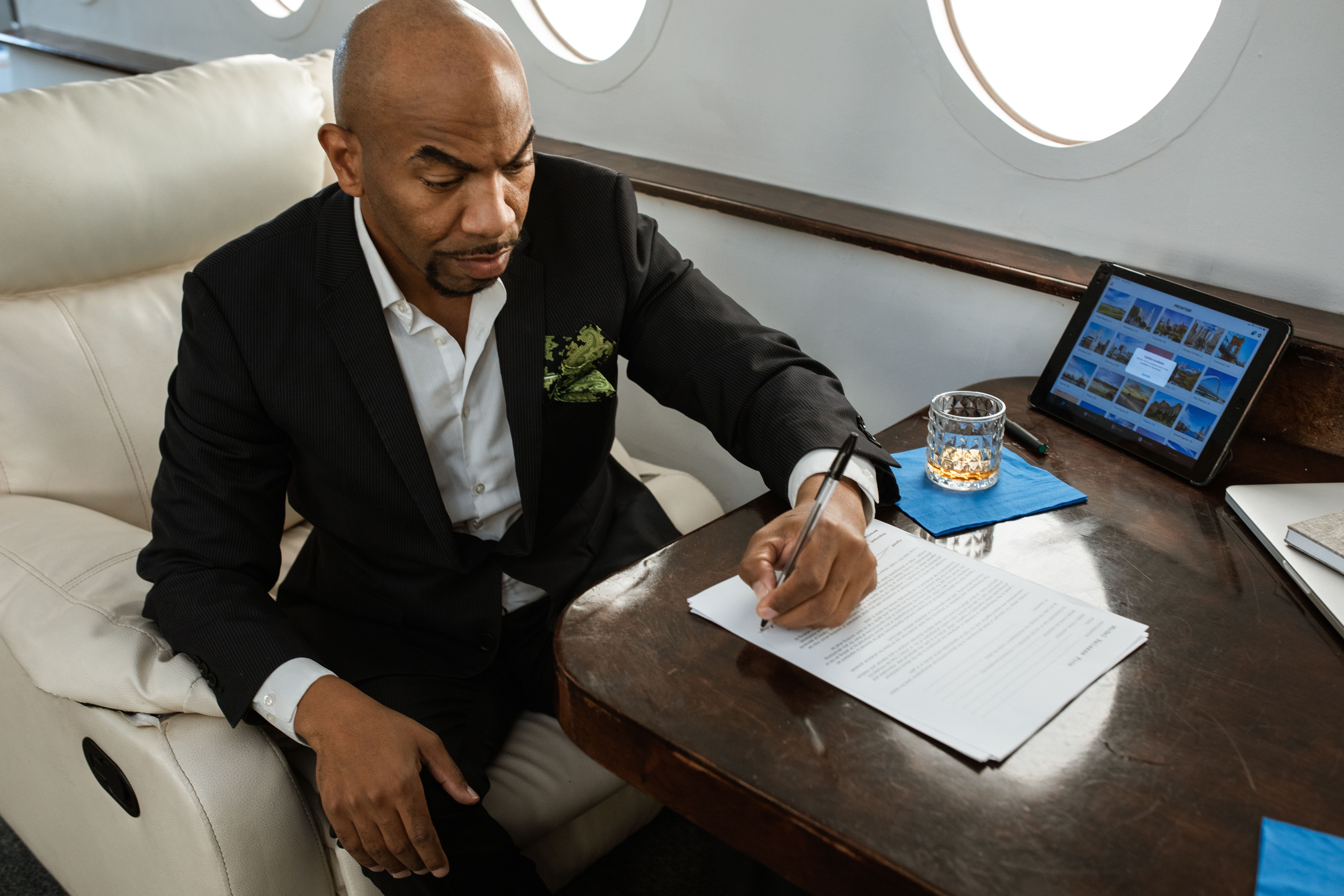 Businessman reviewing legal documents in a private jet cabin on a class-action case