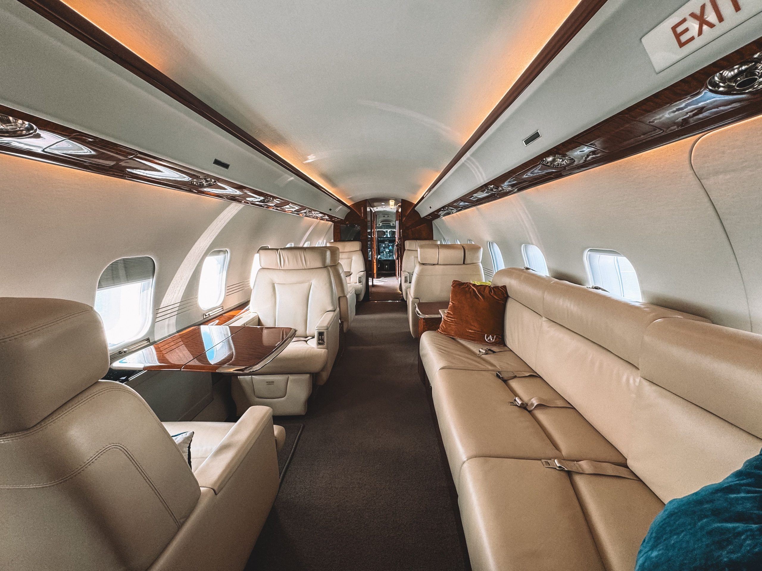 Luxurious private jet interior with cream leather seats and polished wood trim