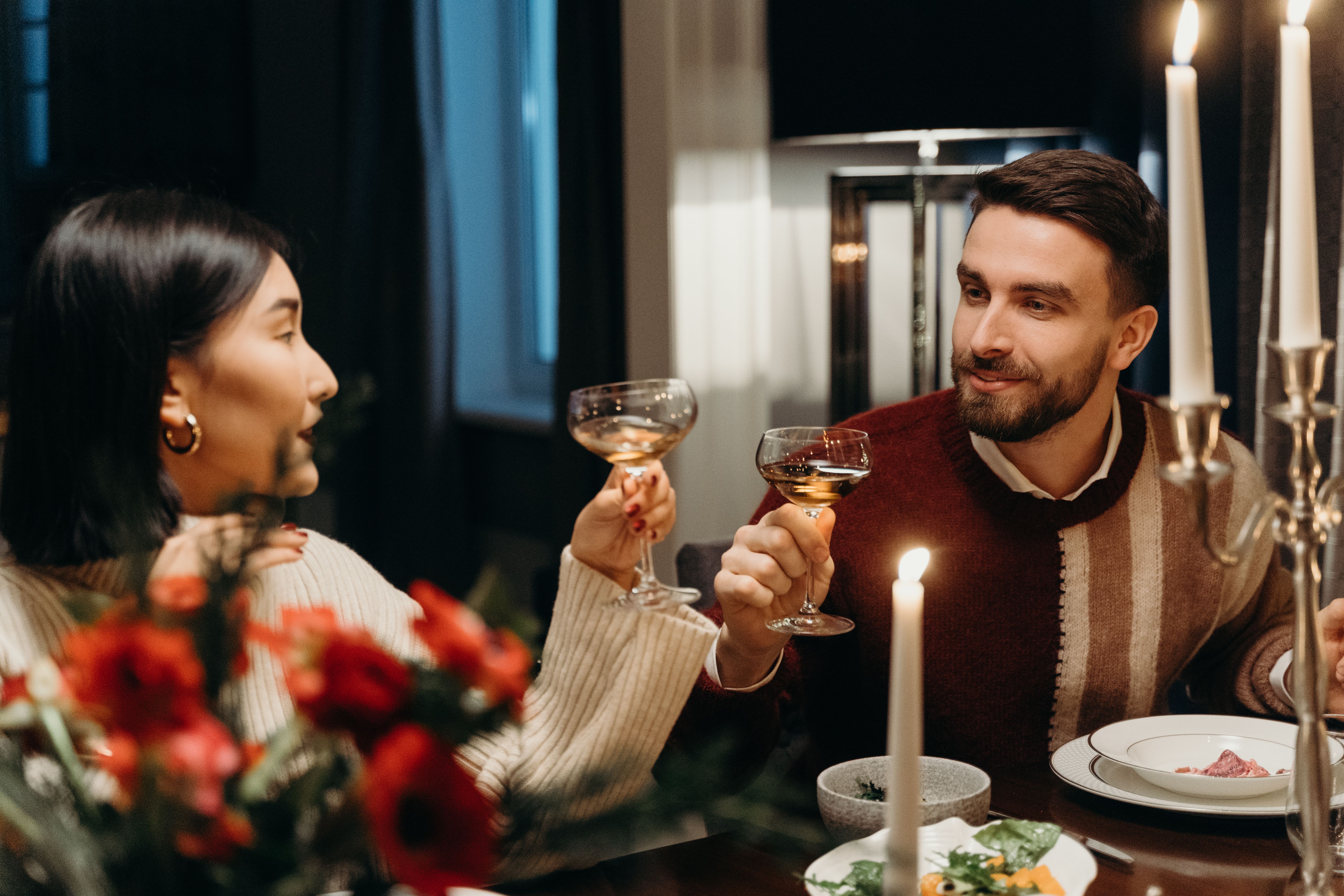 Couple enjoying an intimate candlelit dinner, a romantic setting for connection and shared fantasy.