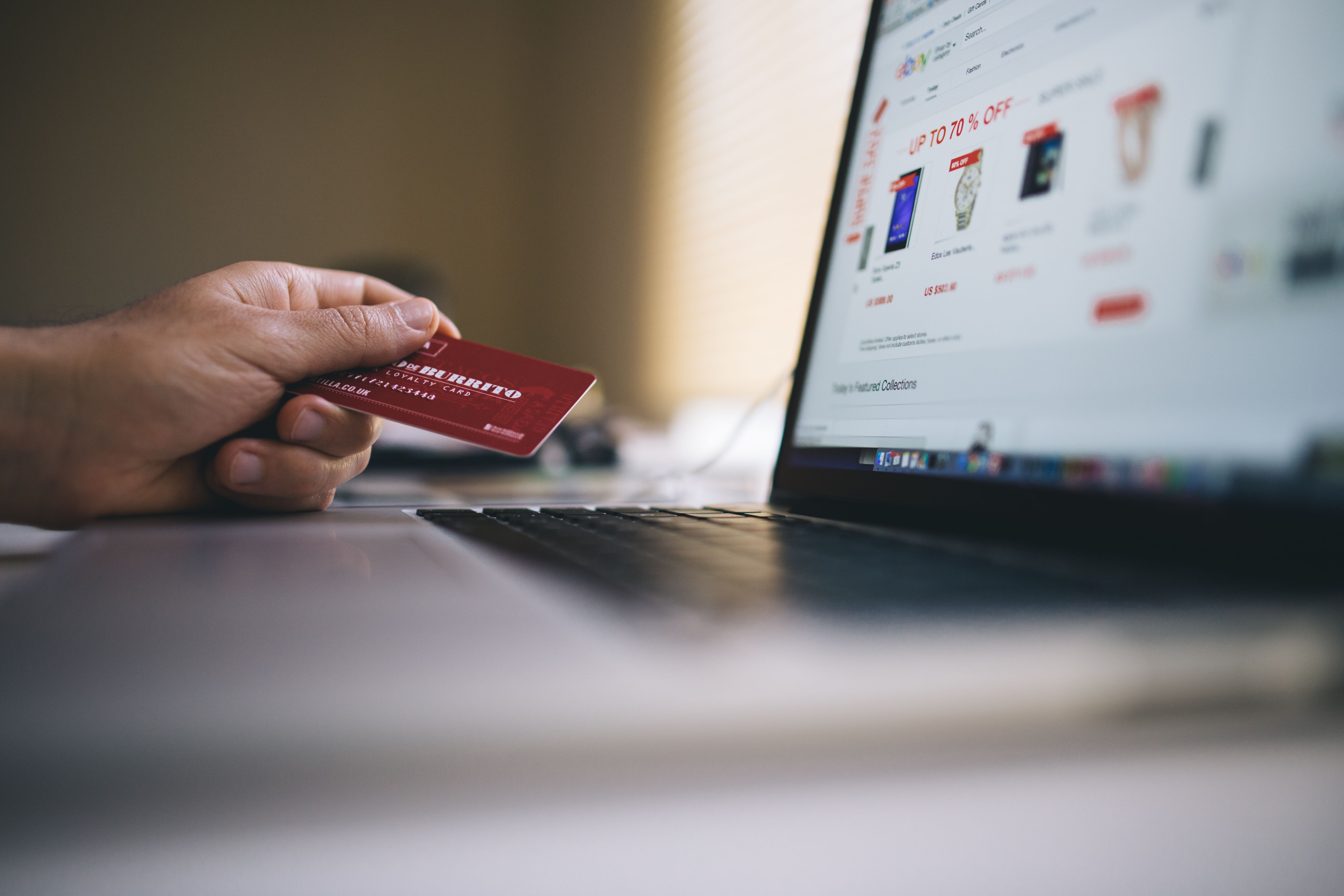Consumer using a credit card to pay for an online purchase on a laptop