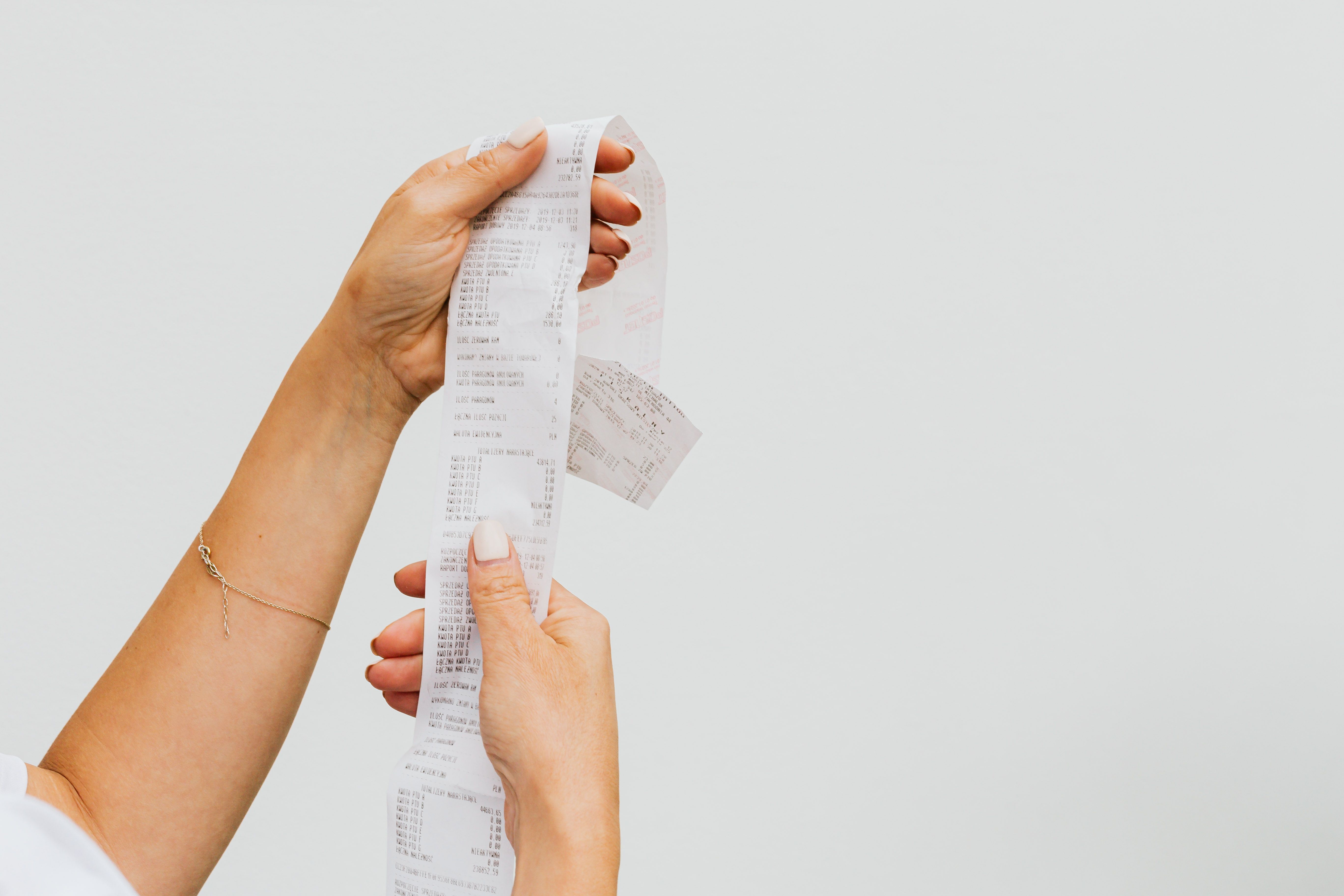 Shopper holding a long receipt as proof of a retail transaction