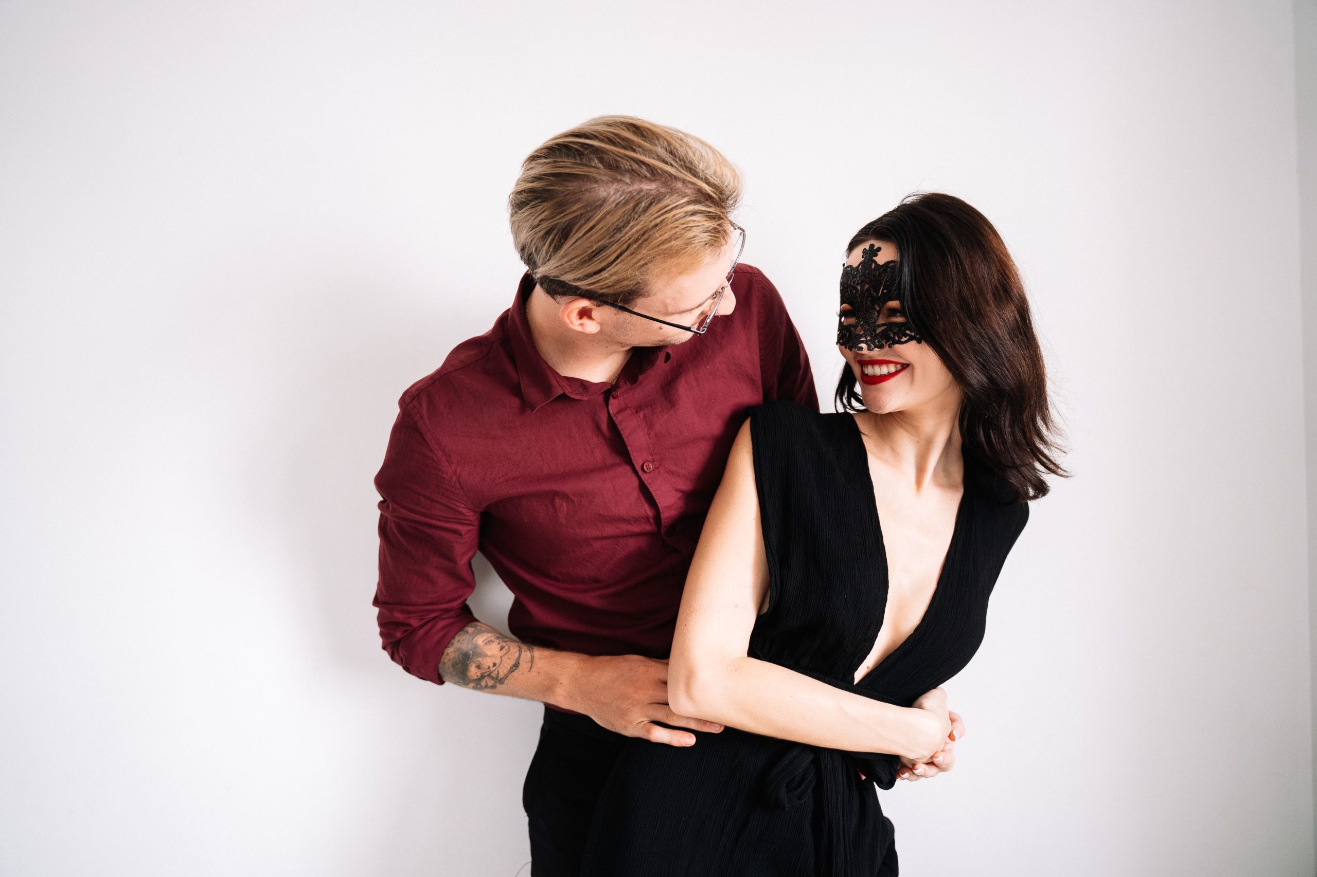 Couple laughing and embracing in playful Halloween costumes, suggesting shared role-play and lighthearted connection.